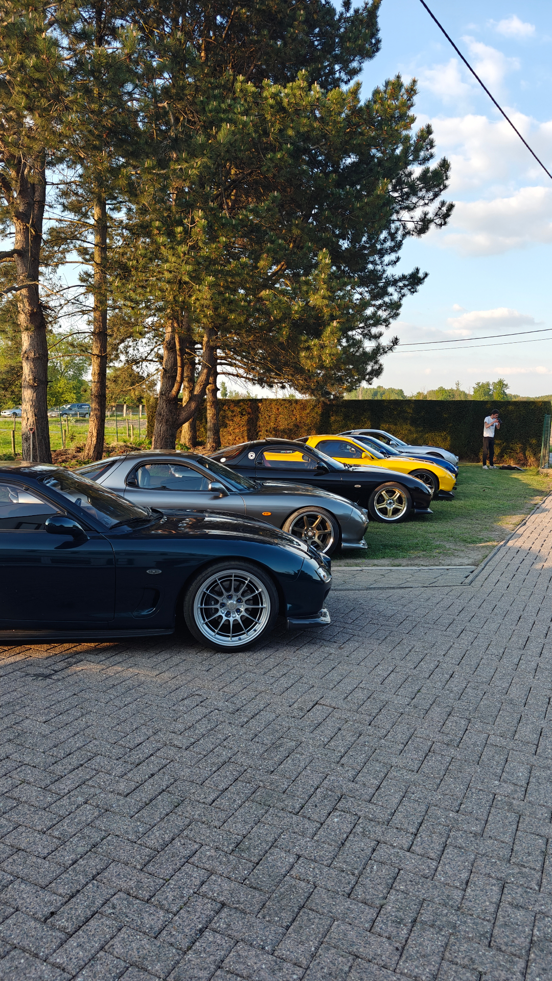 Lineup of Mazda RX-7 sports cars at a VcarsBelgium meet